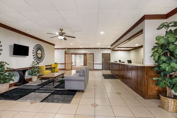 Warm, welcoming lobby at Alice Western Inn with wood front desk and seating area